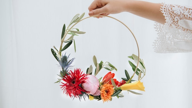 Foto frau, die einen mit blumen verzierten goldenen ring hält