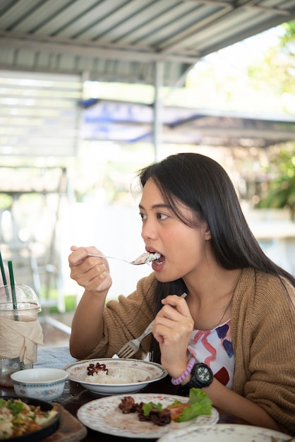 Frau, die Essen auf Esstisch im Restaurant isst