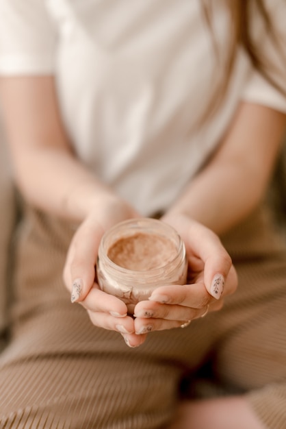 Frau, die Flasche Körpercreme hält