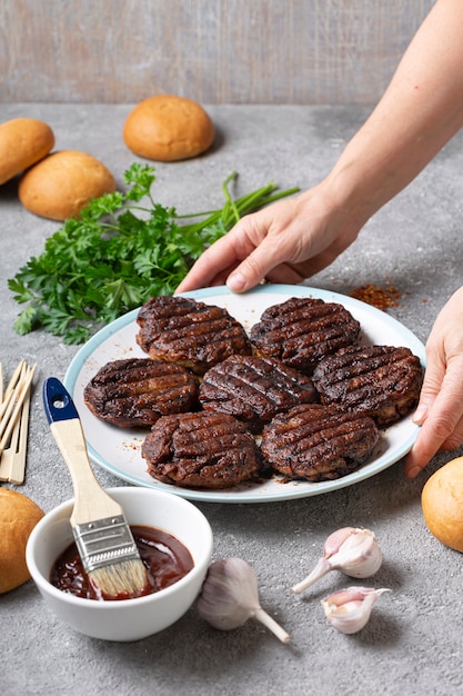 Frau, die Fleischburger zu Hause in der Küche kocht