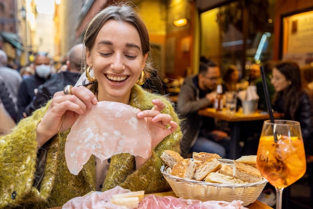 Frau, die Fleischplatte an der Bar im Freien in Italien isst