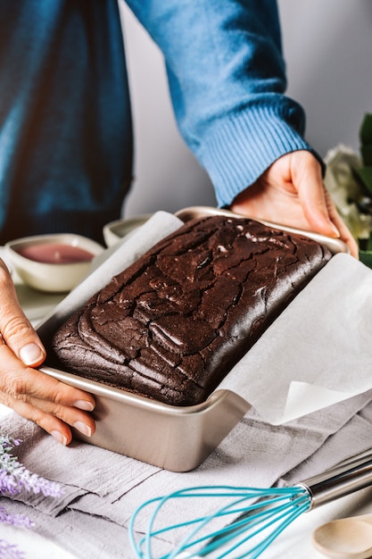 Frau, die Form mit Brotkuchen auf Handtuch setzt