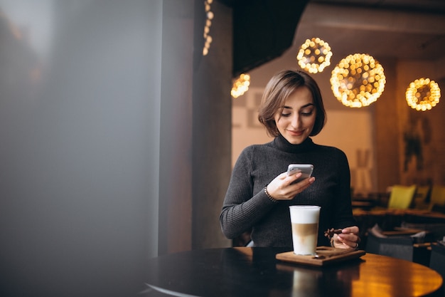 Frau, die Foto eines Kaffees in einem Café macht