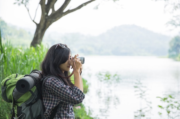 Frau, die Foto mit Kamera beim Wandern macht