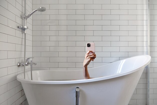 Frau, die Foto mit Smartphone im Badezimmer macht