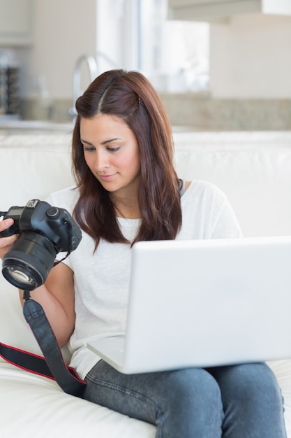 Frau, die Fotos beim Anhalten eines Laptops betrachtet