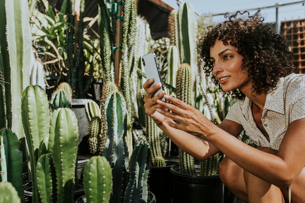 Frau, die Fotos von Kakteen an einem botanischen Garten macht