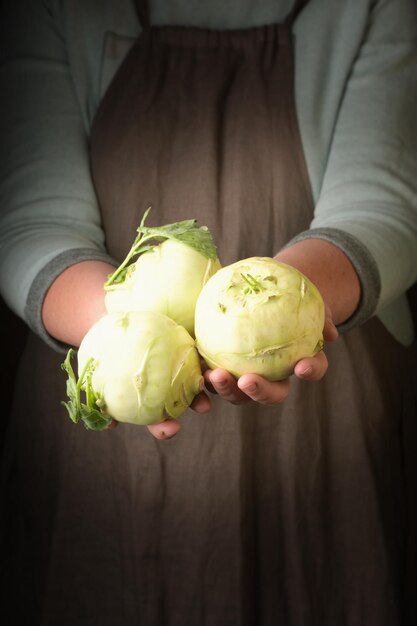 Foto frau, die frisch geerntete kohlrabi-nahaufnahme in der hand hält