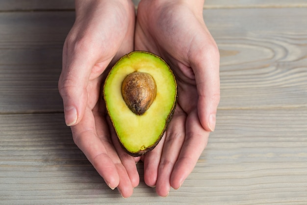 Frau, die frische Avocado zeigt