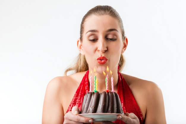 Foto frau, die geburtstag mit kuchen und kerzen feiert