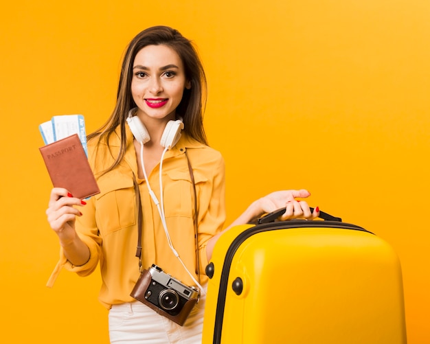 Frau, die Gepäck und Pass mit Flugtickets hält