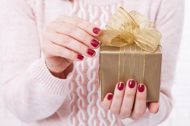 Frau, die Geschenkbox mit Band hält