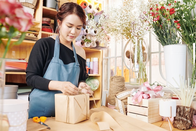 Frau, die Geschenke im Blumenladen einwickelt