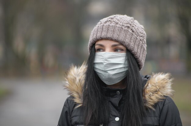 Frau, die Gesichtsmaske wegen Luftverschmutzung oder Virusepidemie in der Stadt trägt