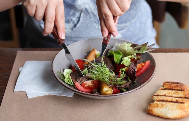 Frau, die gesunden Salat mit Rindfleisch und Gemüse isst