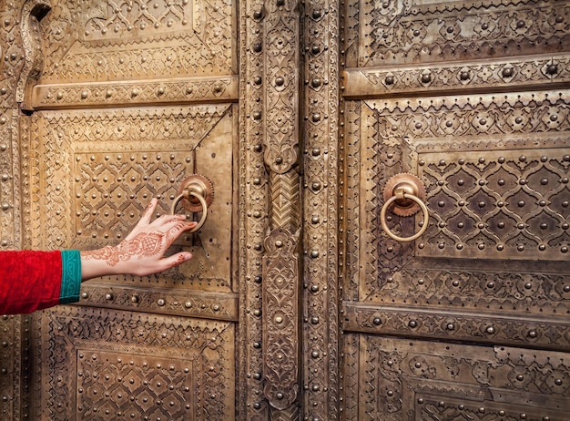 Frau, die goldene Tür in Jaipur öffnet