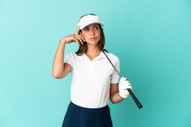 Frau, die Golf über isoliertem blauem Hintergrund spielt, der Zweifel und Denken hat