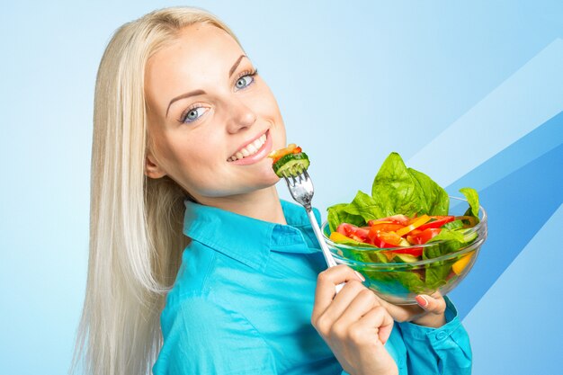 Frau, die grünen Salat mit Tomaten isst