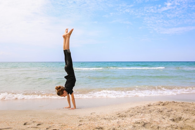 Frau, die Gymnastik am Strand tut