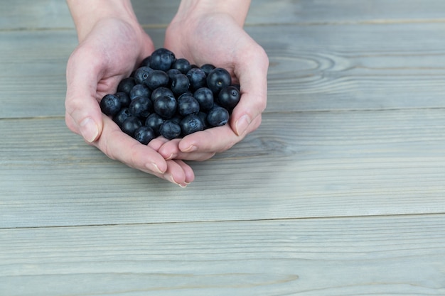 Frau, die Handvoll Blaubeeren zeigt