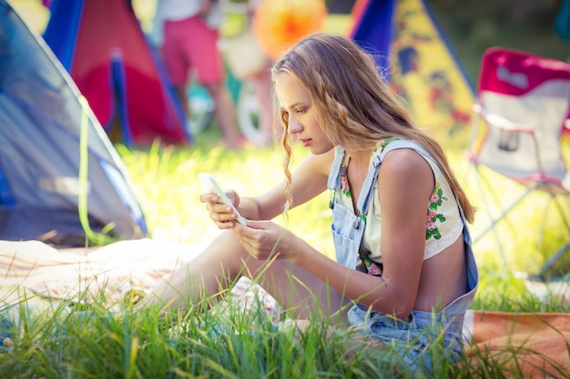 Frau, die Handy am Campingplatz benutzt