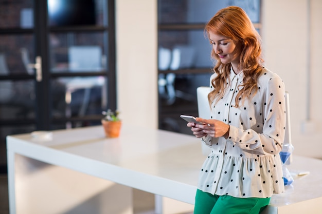 Frau, die Handy im Büro benutzt