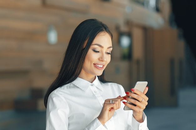 Frau, die Handy im Büro verwendet