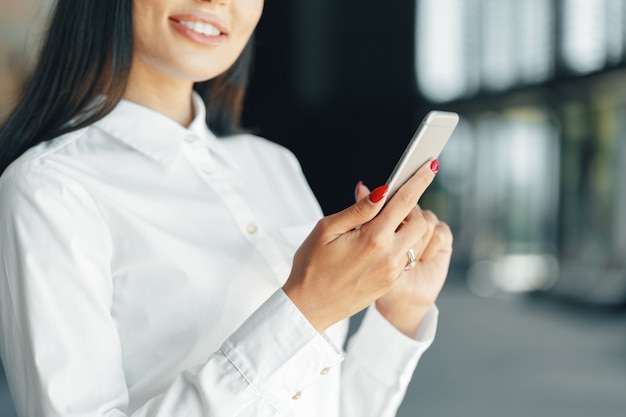 Frau, die Handy im Büro verwendet