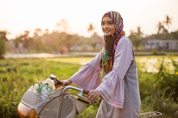 Frau, die Hijab trägt, der ein Fahrrad reitet