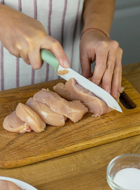 Frau, die Hühnerfleisch selektiven Fokus einlegt