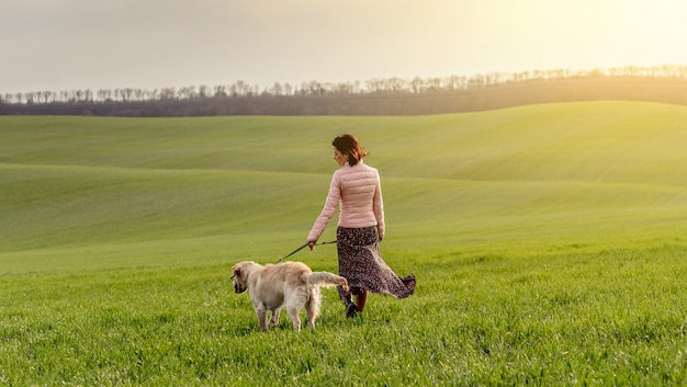 Frau, die Hund auf Feld geht