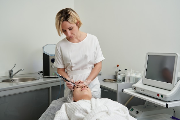 Frau, die Hydro Hydrodermabrasion Peeling-Behandlung im Gesicht bei Cosmetic Beauty Spa Clinic erhält. Hydra