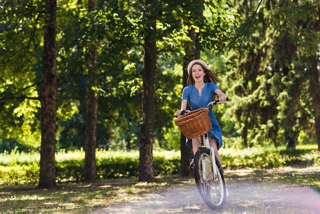 Foto frau, die ihr fahrrad im wald reitet