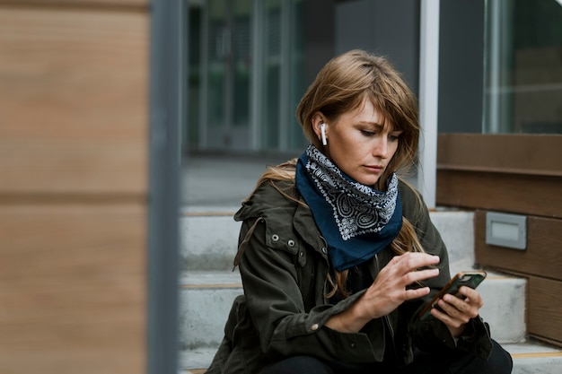 Frau, die ihr Telefon auf einer Treppe benutzt