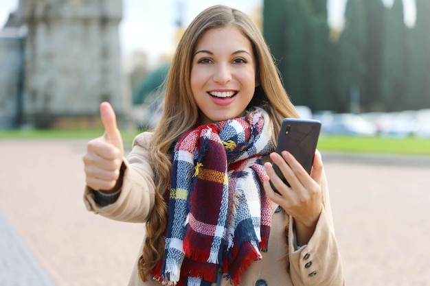 Frau, die ihr Telefon beim Gehen in der Stadt benutzt