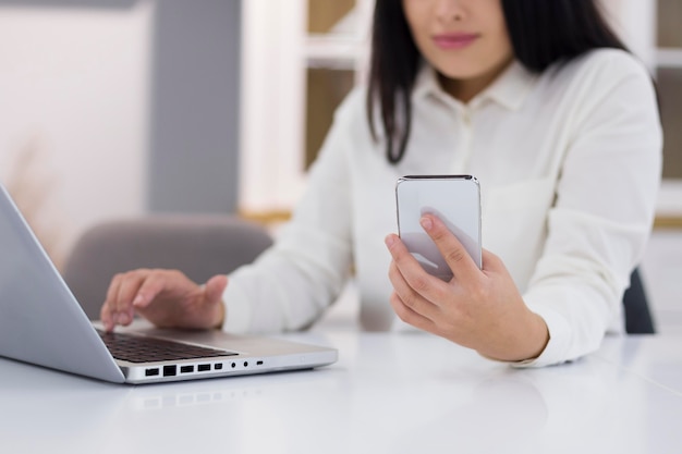 Foto frau, die ihr telefon und laptop für cyber-montag-ereignis überprüft