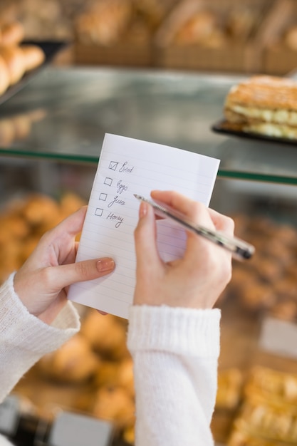 Frau, die ihre Einkaufsliste überprüft