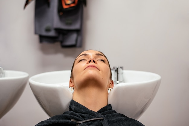 Frau, die ihre Haare in einem Salon waschen lässt