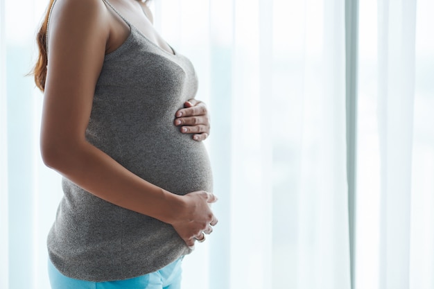 Frau, die ihren Babybauch berührt