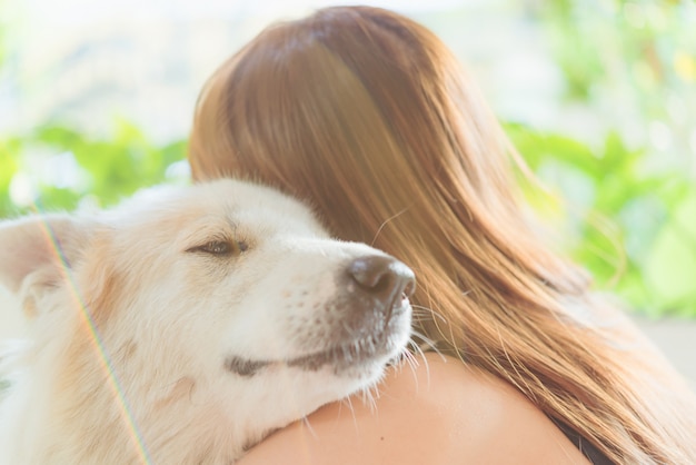 Frau, die ihren großen Hund, Glück und Freundschaft ihrer Hundefreundlichen Haustiernahaufnahme umarmt