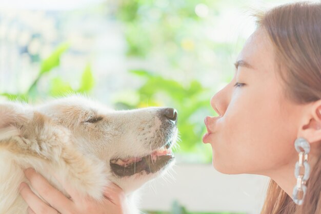 Frau, die ihren großen Hund, Glück und Freundschaft ihrer Hundefreundlichen Haustiernahaufnahme umarmt