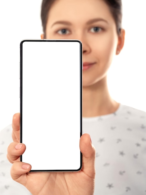 Frau, die ihren Handybildschirm zeigt Frau mit dem Smartphone, das über weißem Hintergrundmodell steht