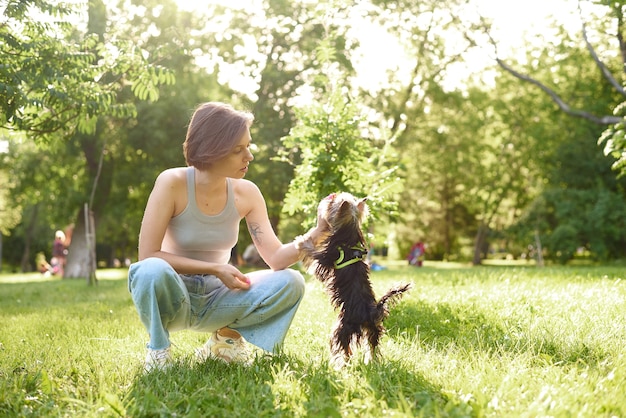 Frau, die ihren Hund am Park trainiert