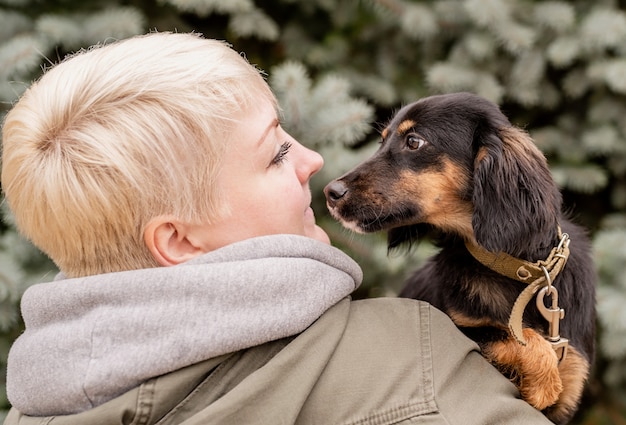 Frau, die ihren Hund in einem Park umarmt