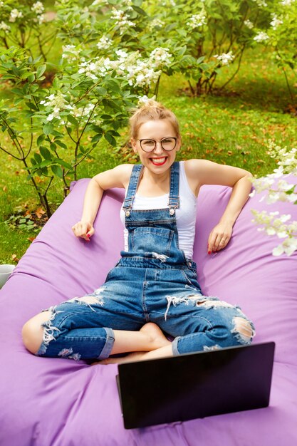 Frau, die ihren Laptop im Garten benutzt