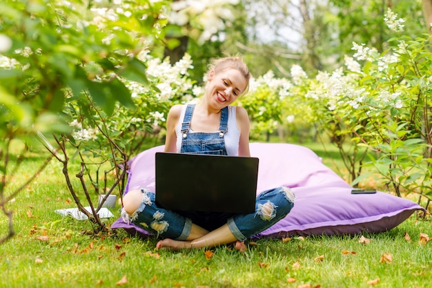 Frau, die ihren Laptop im Garten benutzt