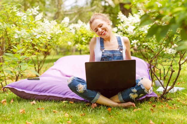 Frau, die ihren Laptop im Garten benutzt