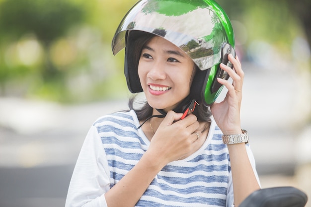 Frau, die ihren Motorradhelm befestigt