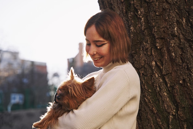 Frau, die ihren Yorkshire-Terrierhund umarmt