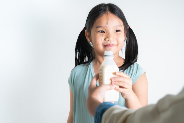 Frau, die ihrer Tochter eine Flasche Milch zu Hause gibt